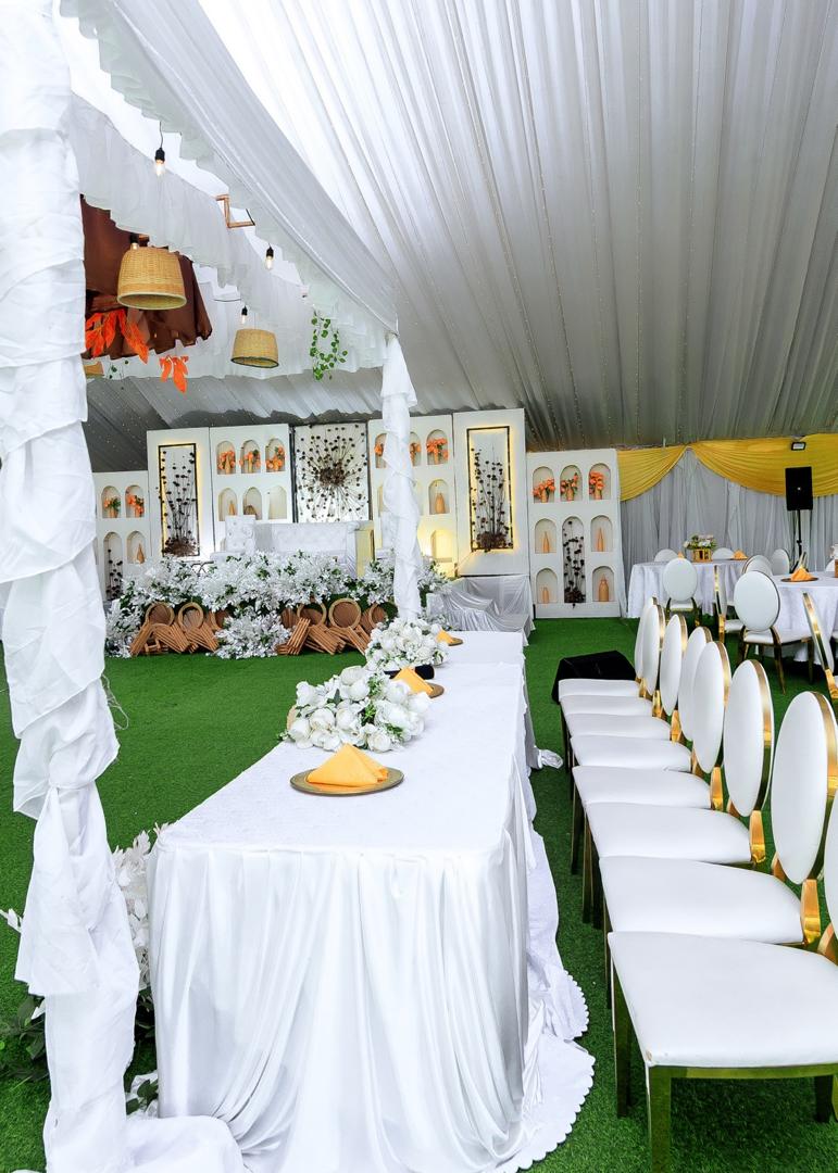 Outdoor reception with white draping and gold chairs
